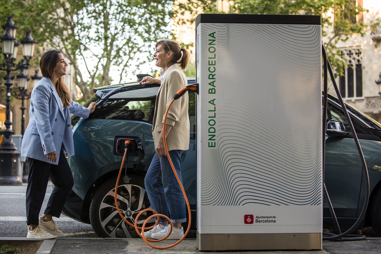 Dos personas haciendo uso de un punto de recarga eléctrico de Endolla Barcelona