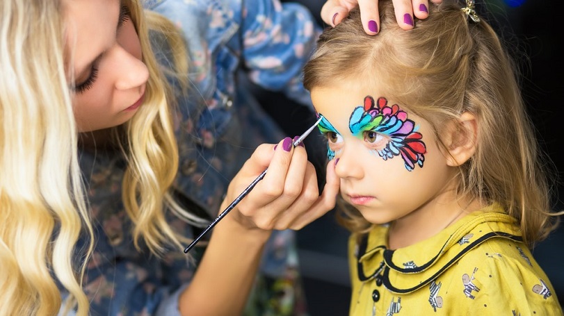 Niña pintándose la cara con los maquillajes representativos de América, Asia y África