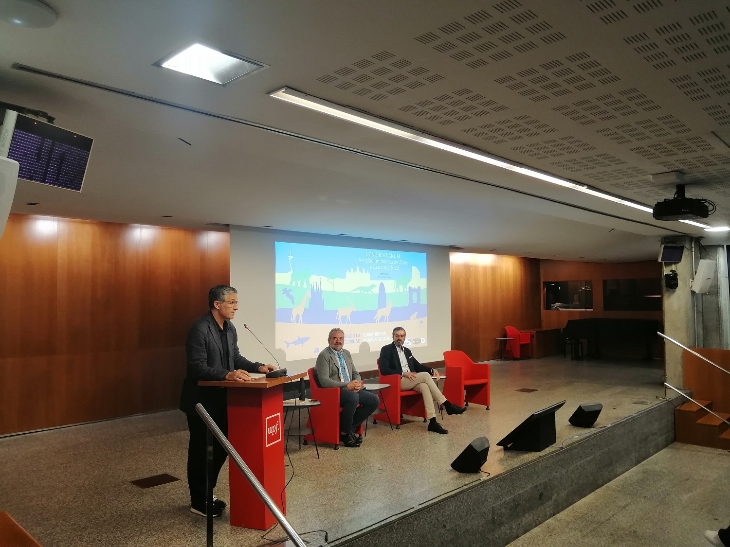 Tres personas haciendo una presentación sobre un escenario
