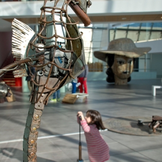 Una nena mirant a un cavallet de mar fet de ferro