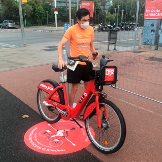 Un usuari al costat d'una bicicleta Bicing