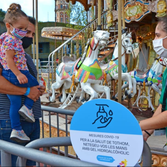 Un pare i la seva filla accedint al carrousel del Parc d'Atraccions Tibidabo