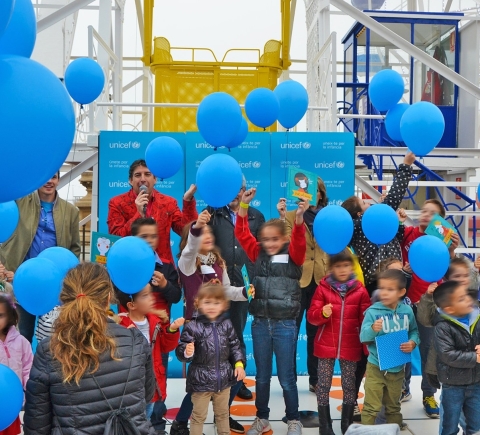 Celebració d'una festa d'Unicef, plena de nens i globus blaus, al Parc d'Atraccions Tibidabo
