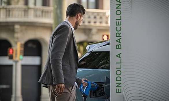 Un usuari recarregant el cotxe elèctric a un punt Endolla