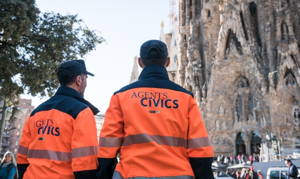Dos agentes cívicos en horario de servicio delante de la Sagrada Família velando por la convivencia en espacios de gran afluencia  