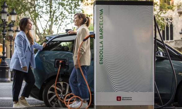 Dos persones fent ús d'un punt de recàrrega elèctric d'Endolla Barcelona
