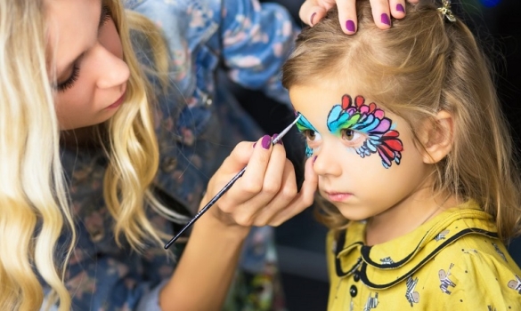 Nena pintant-se la cara amb els maquillatges representatius d'Amèrica, Àsia i Àfrica