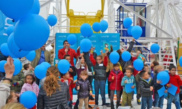 Celebració d'una festa d'Unicef, plena de nens i globus blaus, al Parc d'Atraccions Tibidabo
