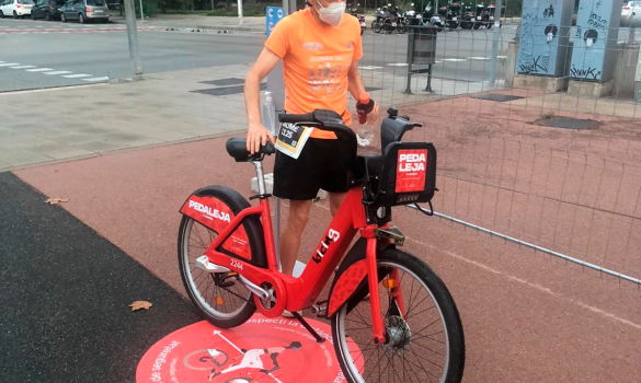 Un usuari al costat d'una bicicleta Bicing