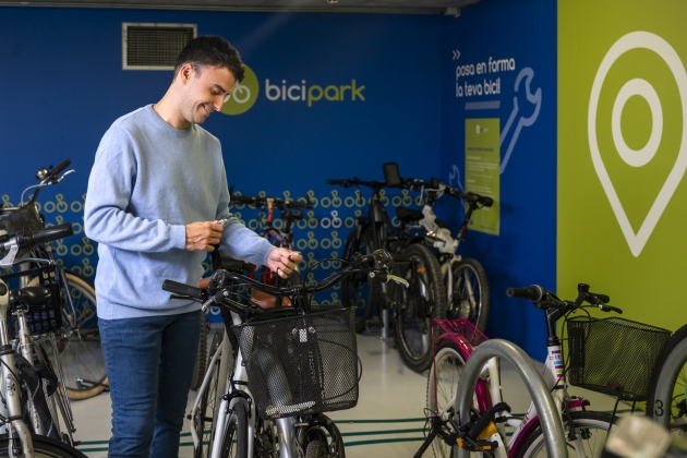A boy picking up his bike from a Biciparc