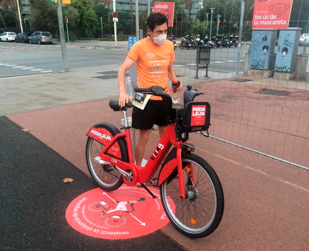 Un usuari al costat d'una bicicleta Bicing