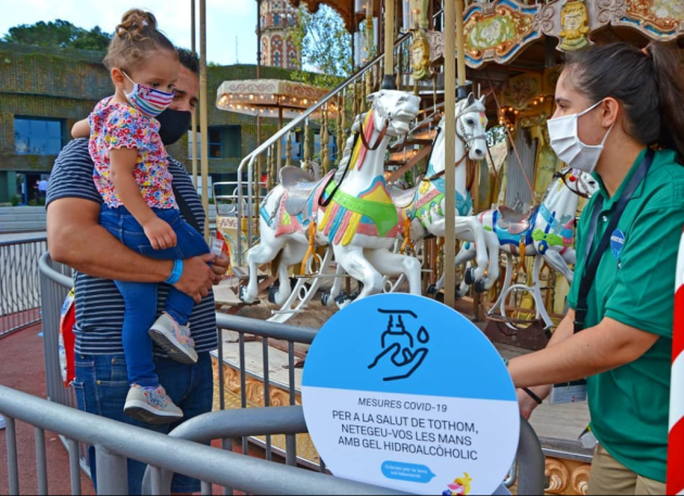 Un pare i la seva filla accedint al carrousel del Parc d'Atraccions Tibidabo